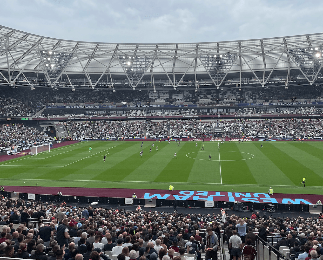  London Stadium packed with fans during a West Ham United home match, viewed from the lower tier