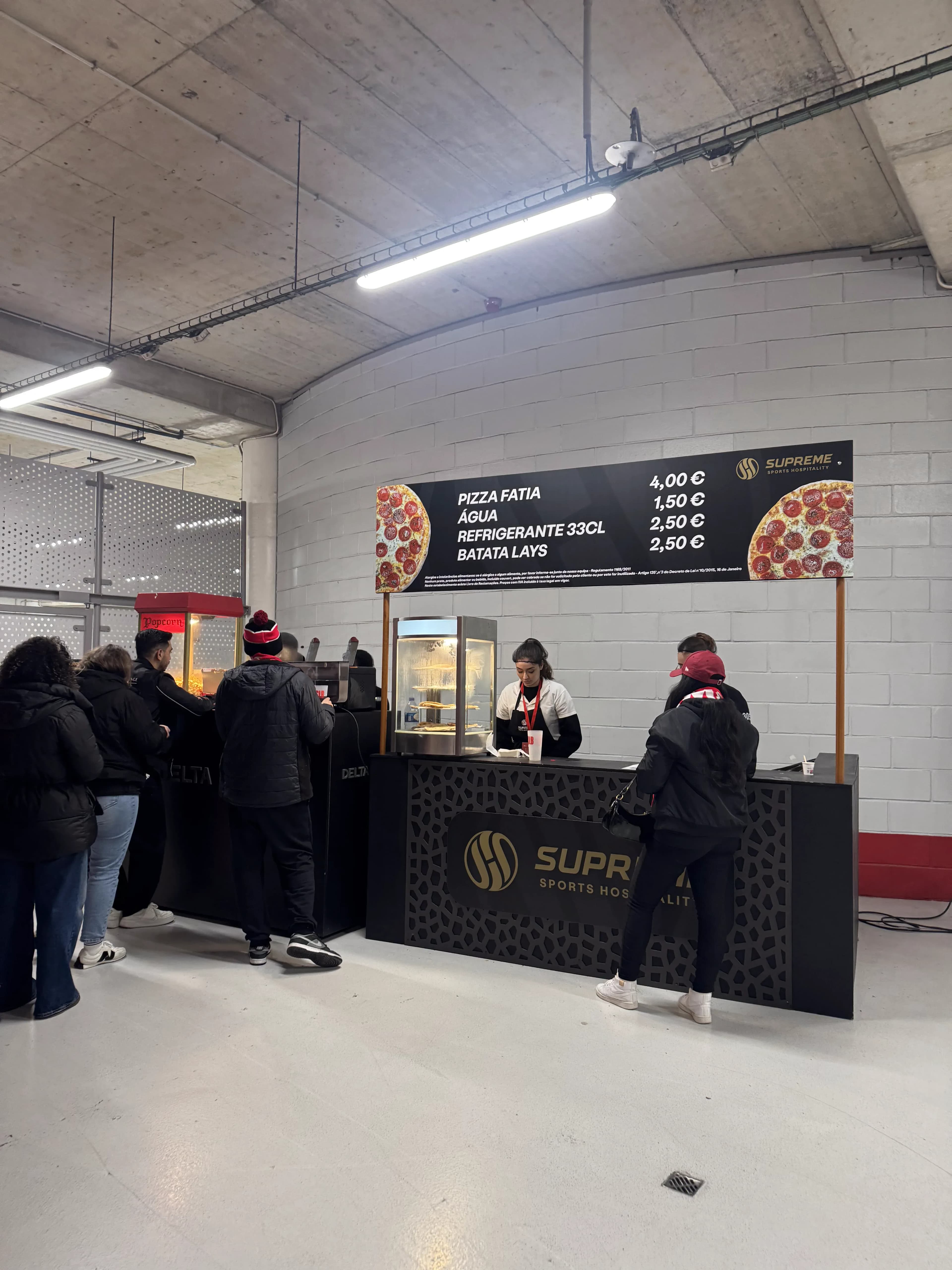 Pizza and snack stand in the Estádio da Luz concourse with fans queuing for food during a Benfica matchday